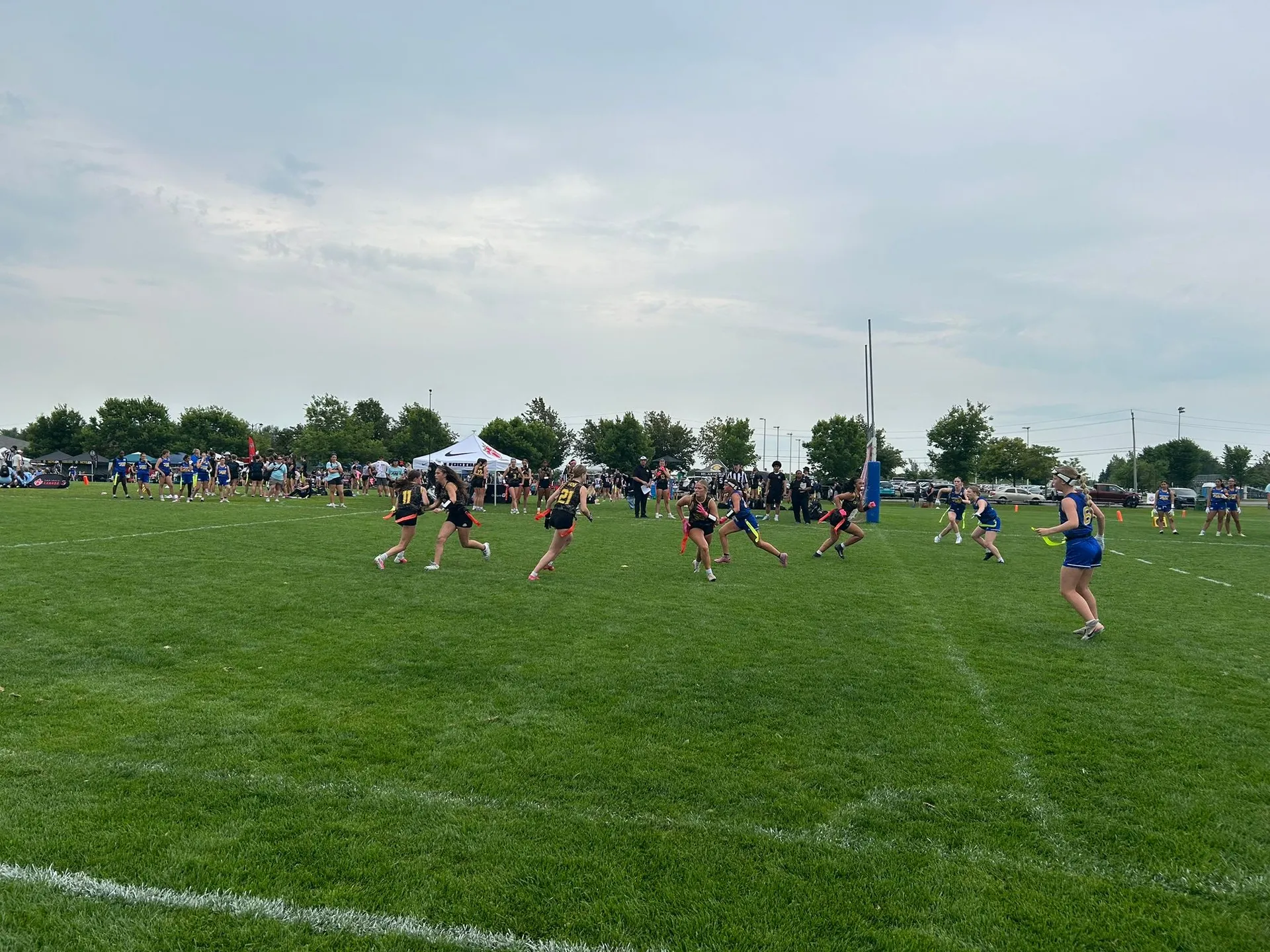 Girls competing in an authentic flag football game on a grass field