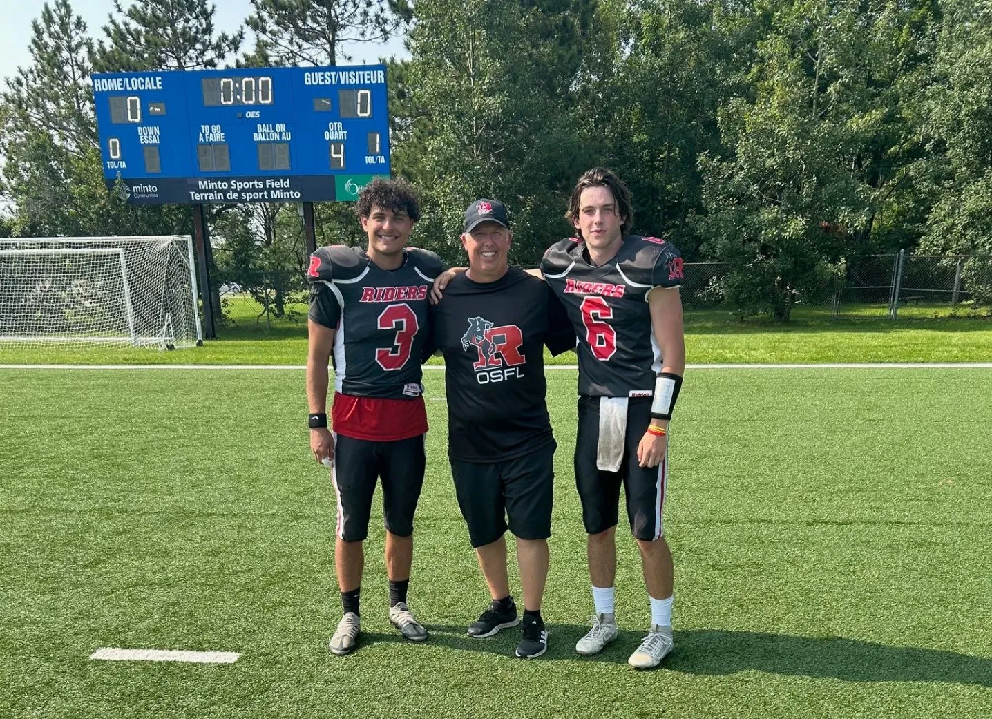 Two high-school quarterbacks training with their coach on an Ottawa football field